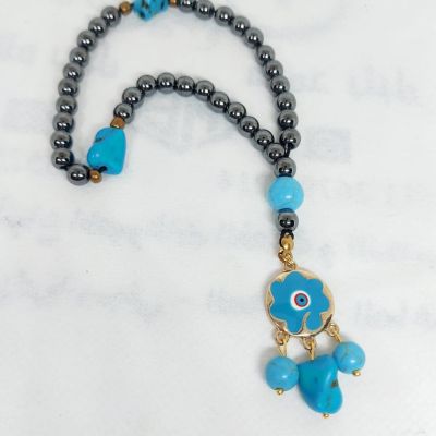 A prayer necklace made from hematite stones, with turquoise spacers.