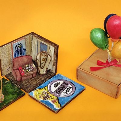 A small gift box with a scene from the movie Up inside