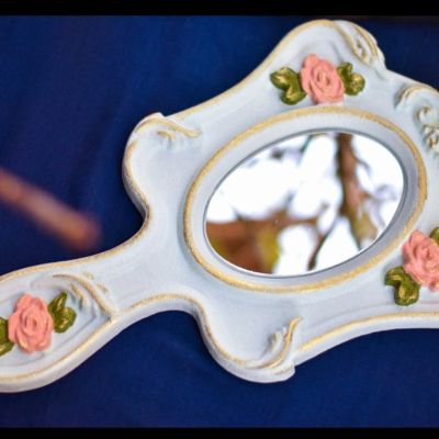 Hand mirror decorated with a prominent rose