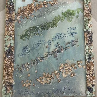 A wooden tablo covered with resin and coloured stones